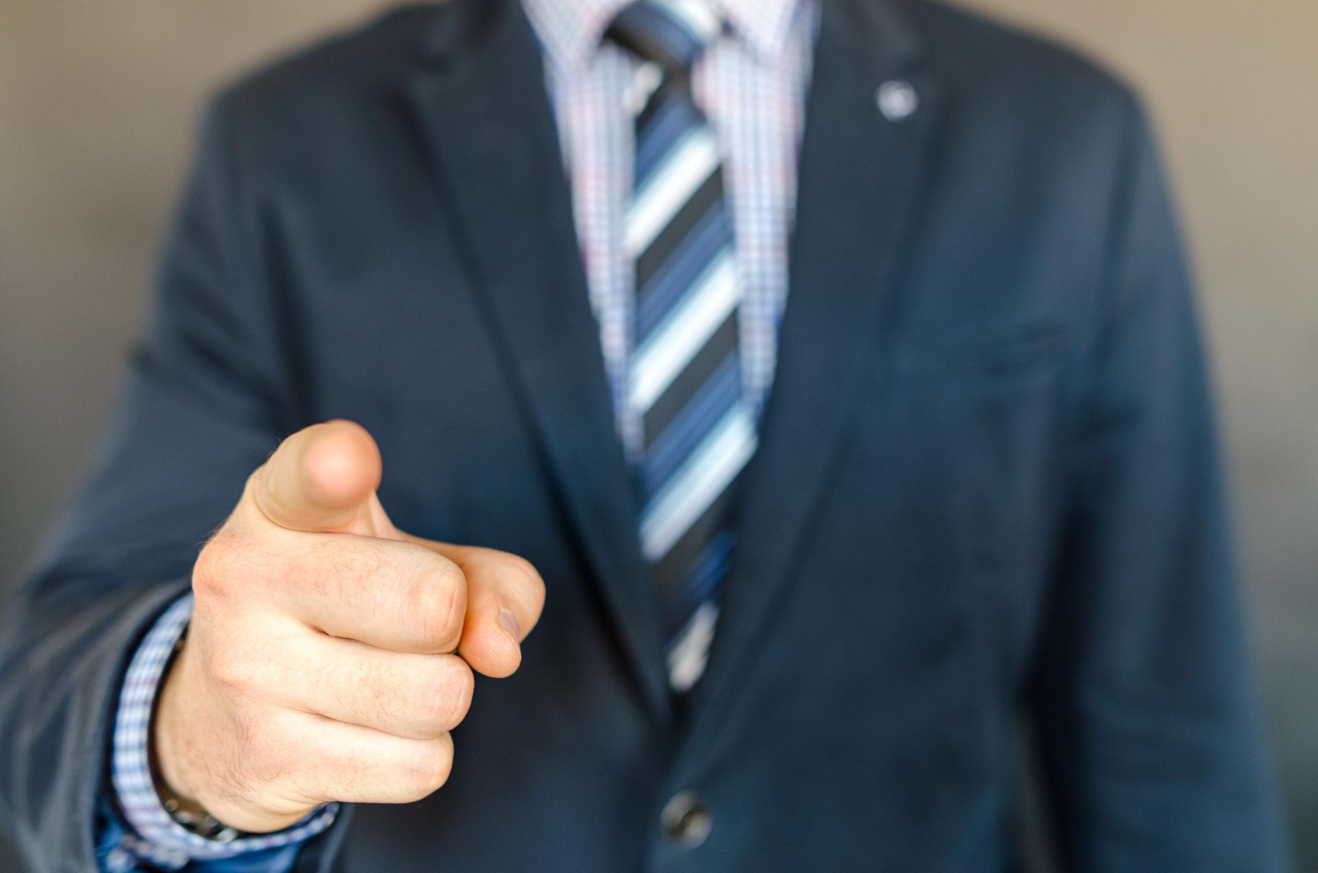 Man pointing toward viewers while considering trust in AI-generated advertising and brand referrals