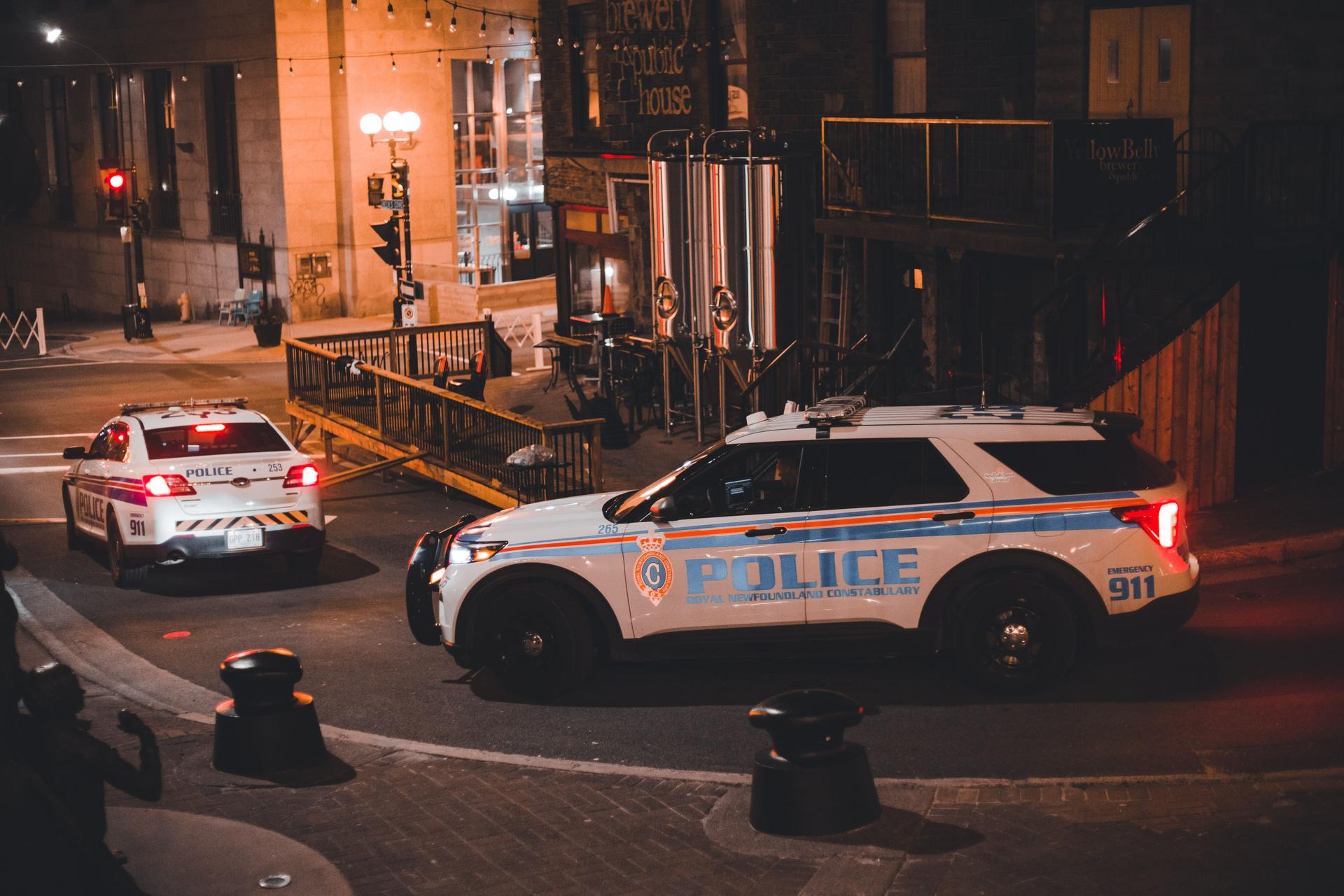 Police Vehicles in Anthropic AI Tip Test Police vehicles parked at night, illustrating the real-world impact of Anthropic's false AI-generated homicide tip.