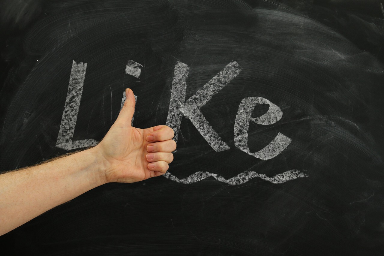 Thumbs-up gesture symbolizing a consumer's willingness to recommend a brand after AI ad disclosure
