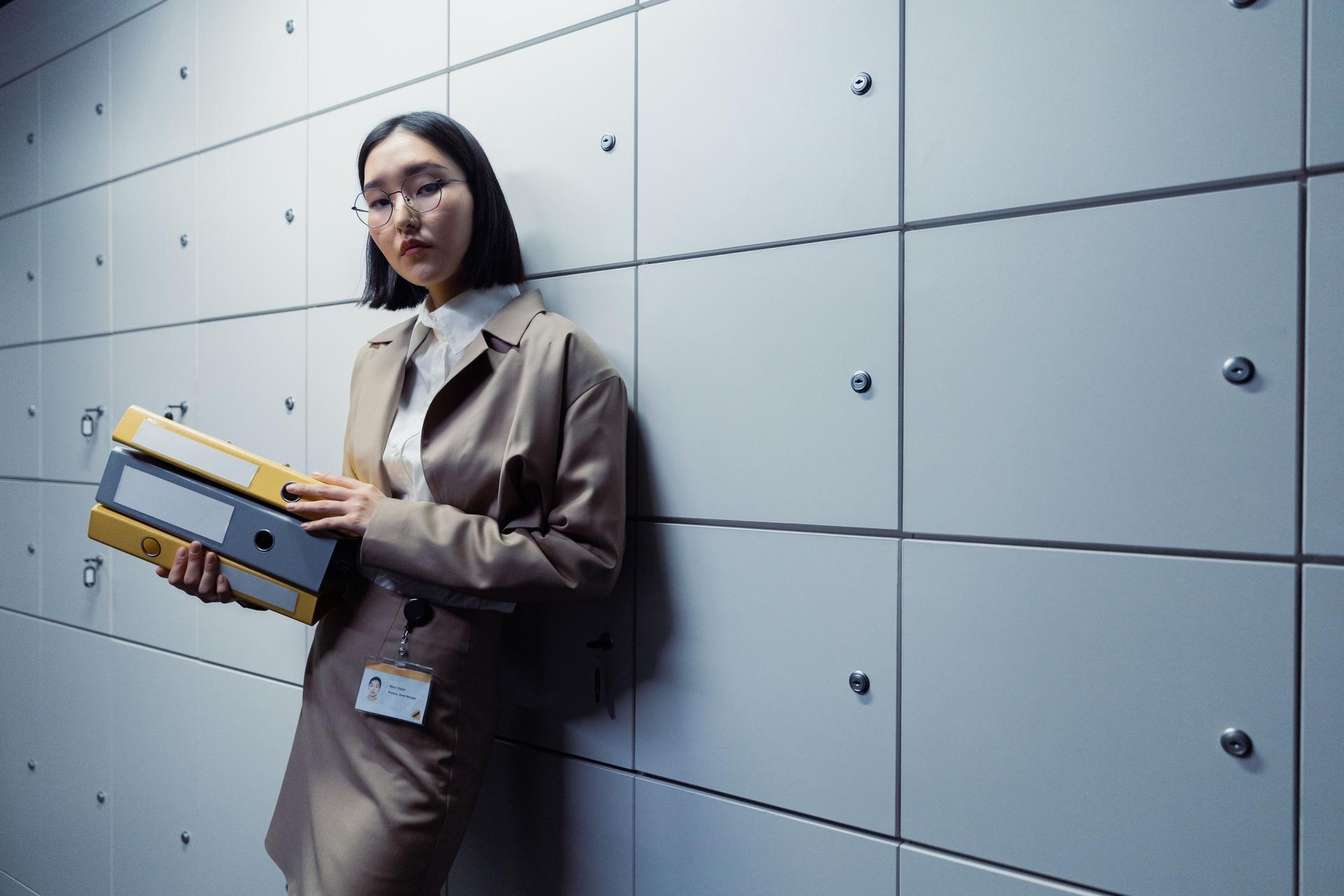 A businesswoman holding folders in a serious setting, reflecting the tech industry's accountability issues amid AI transparency debates