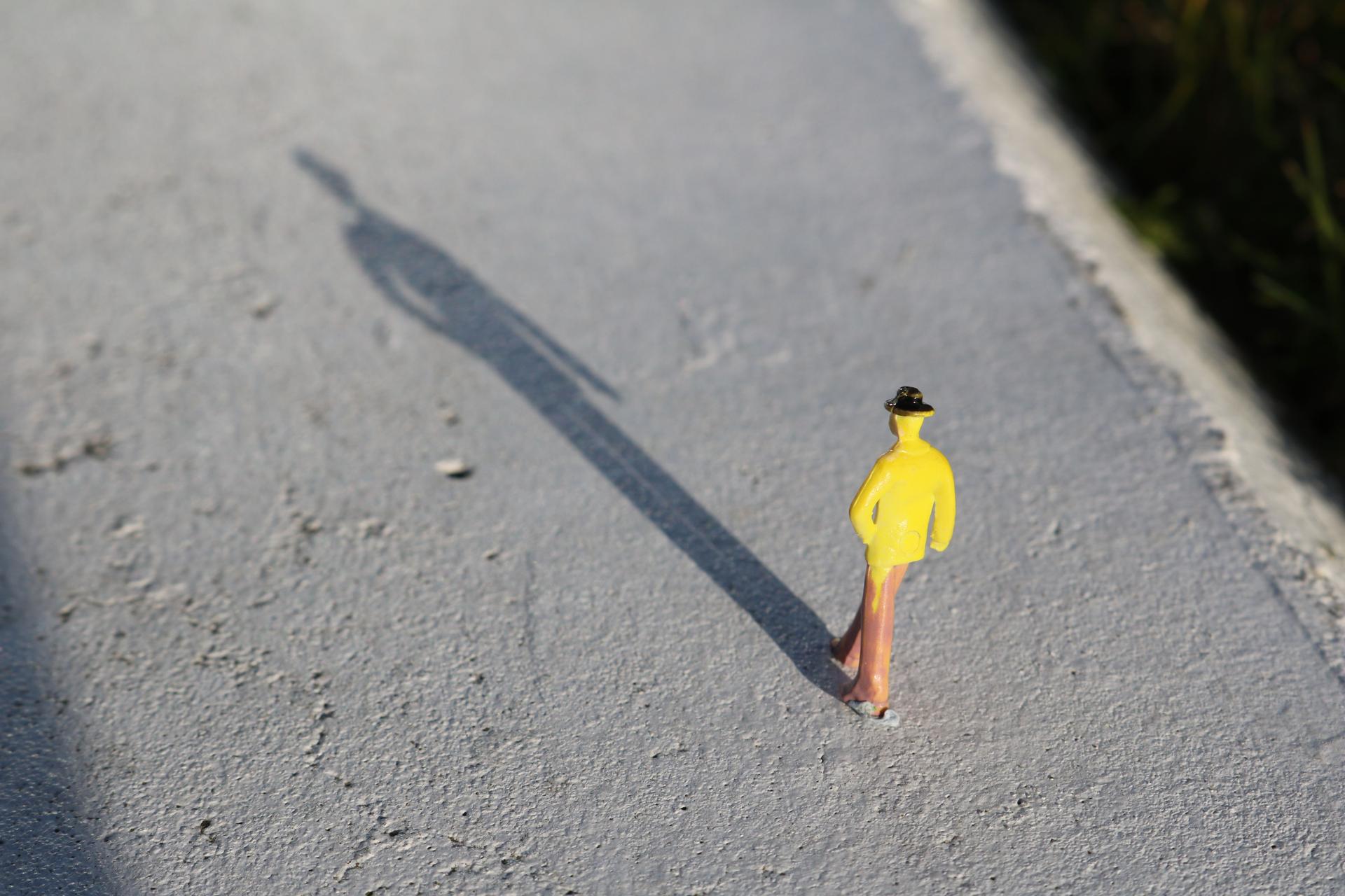 Toy figure casting a long shadow, symbolizing consumer uncertainty about AI-generated advertising disclosures
