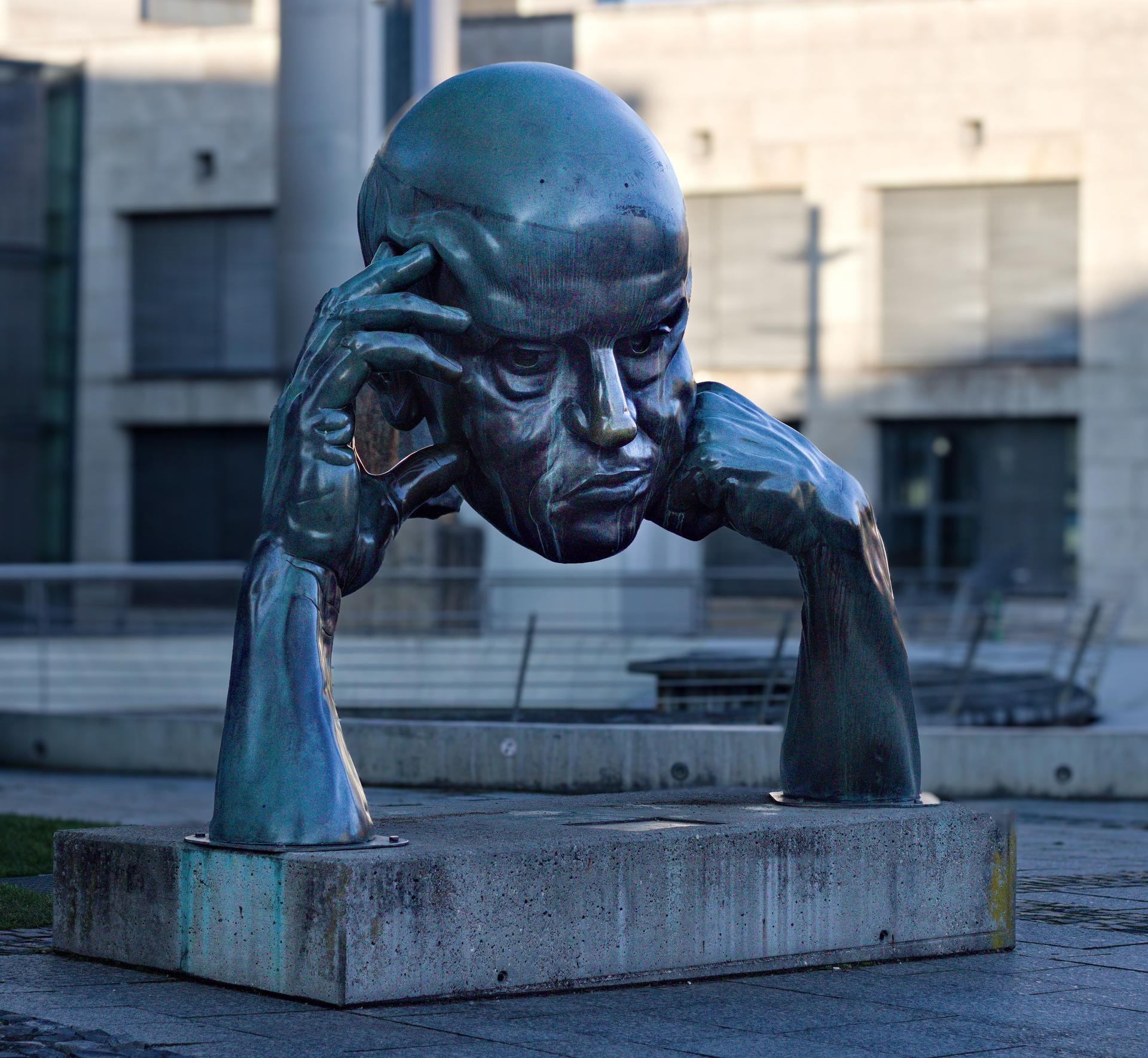 Contemplative Sculpture and AI Detection Insight A contemplative bronze sculpture symbolizes public skepticism in the face of AI deception, including deepfakes.