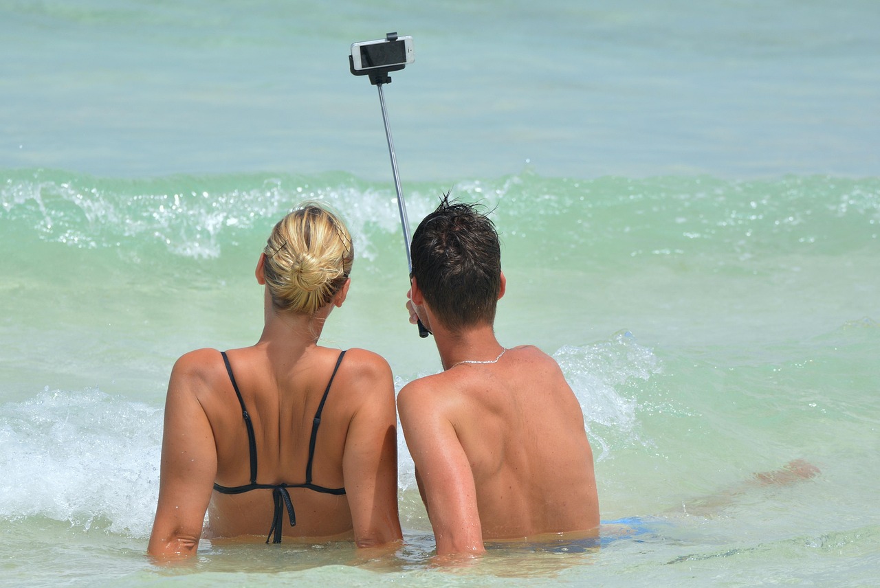 A couple takes a selfie at the beach, symbolizing how influencers share daily AI experiences with ChatGPT.