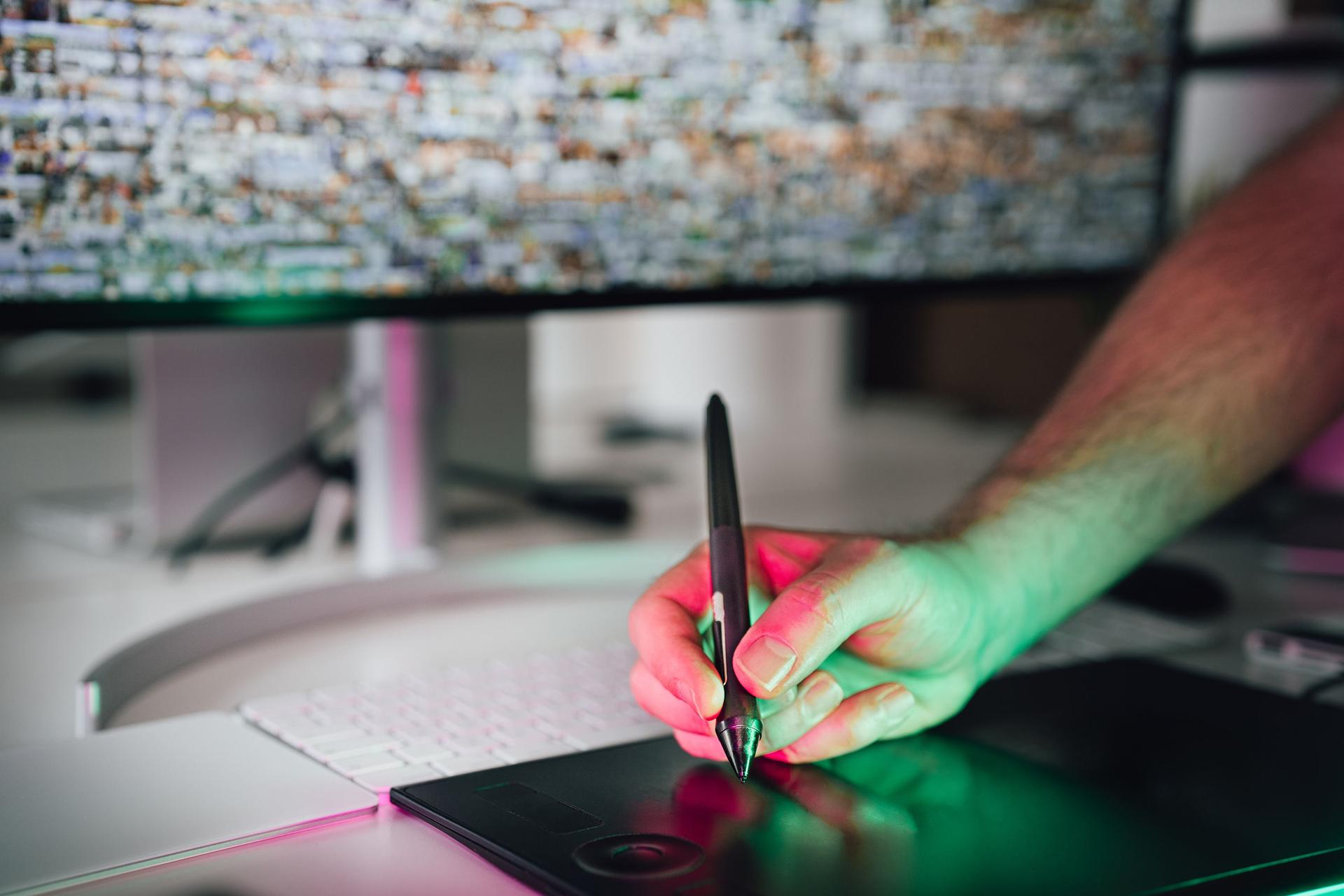 A developer using a graphic tablet illustrating new software alternatives to Adobe, emphasizing AI integration.