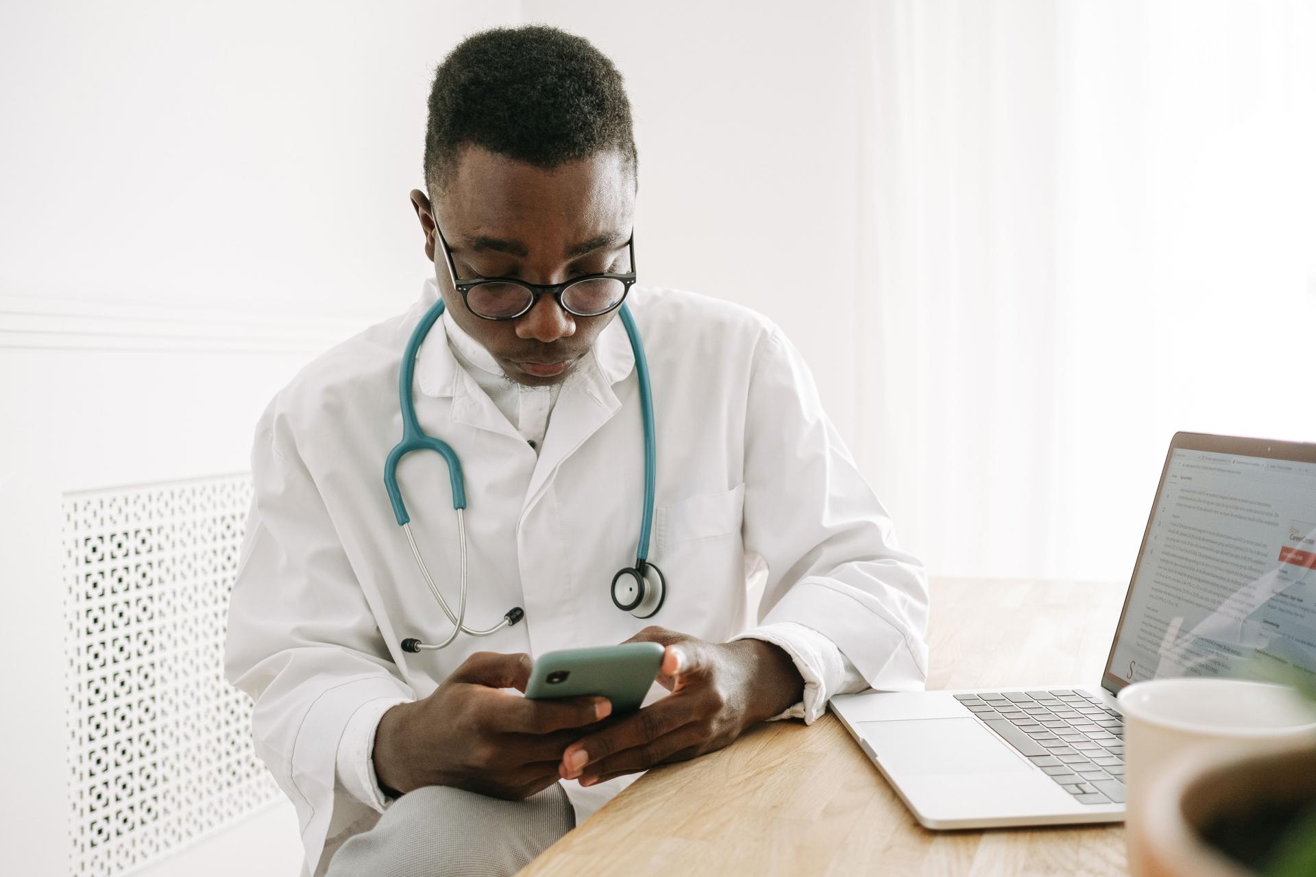 A doctor using his smartphone to access AI-driven diagnostic tools in a medical setting