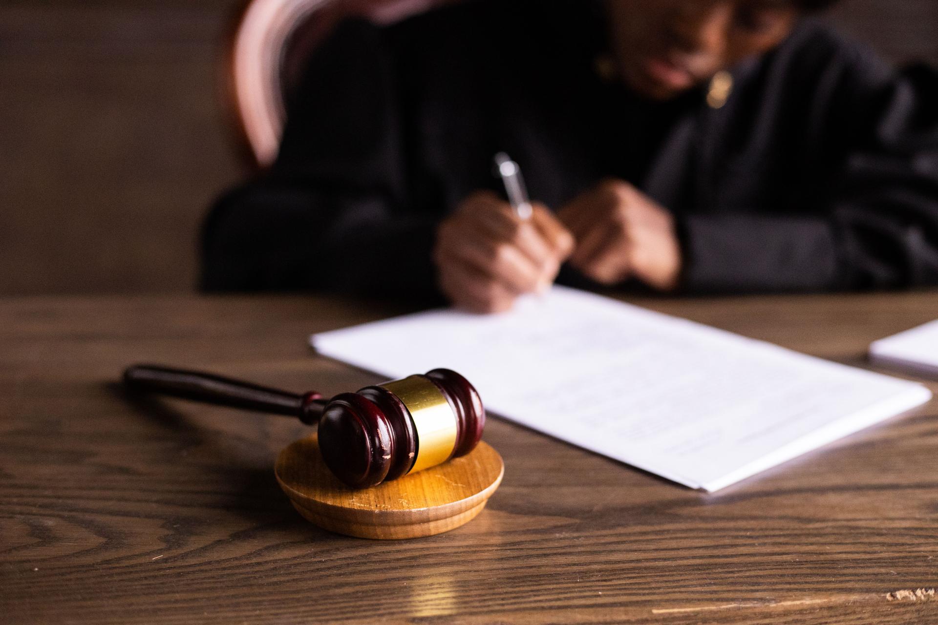Judge Signing Papers Reflecting AI Ethics in Law Judge overseeing legal documents highlights accountability in AI usage under California's Mandatory AI Disclosure laws.