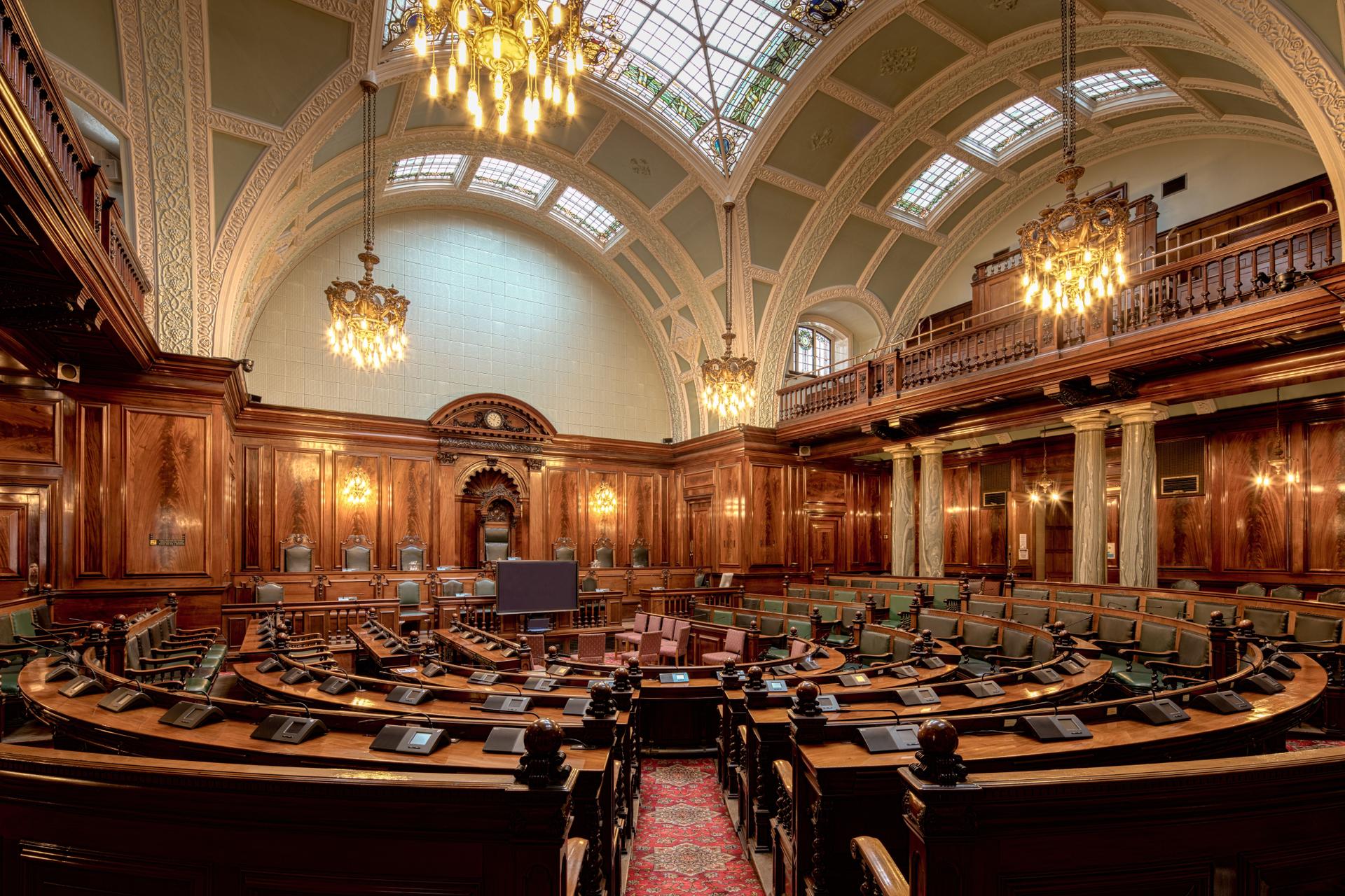 Legislative chamber highlighting the need for ai laws and governance in managing technology.