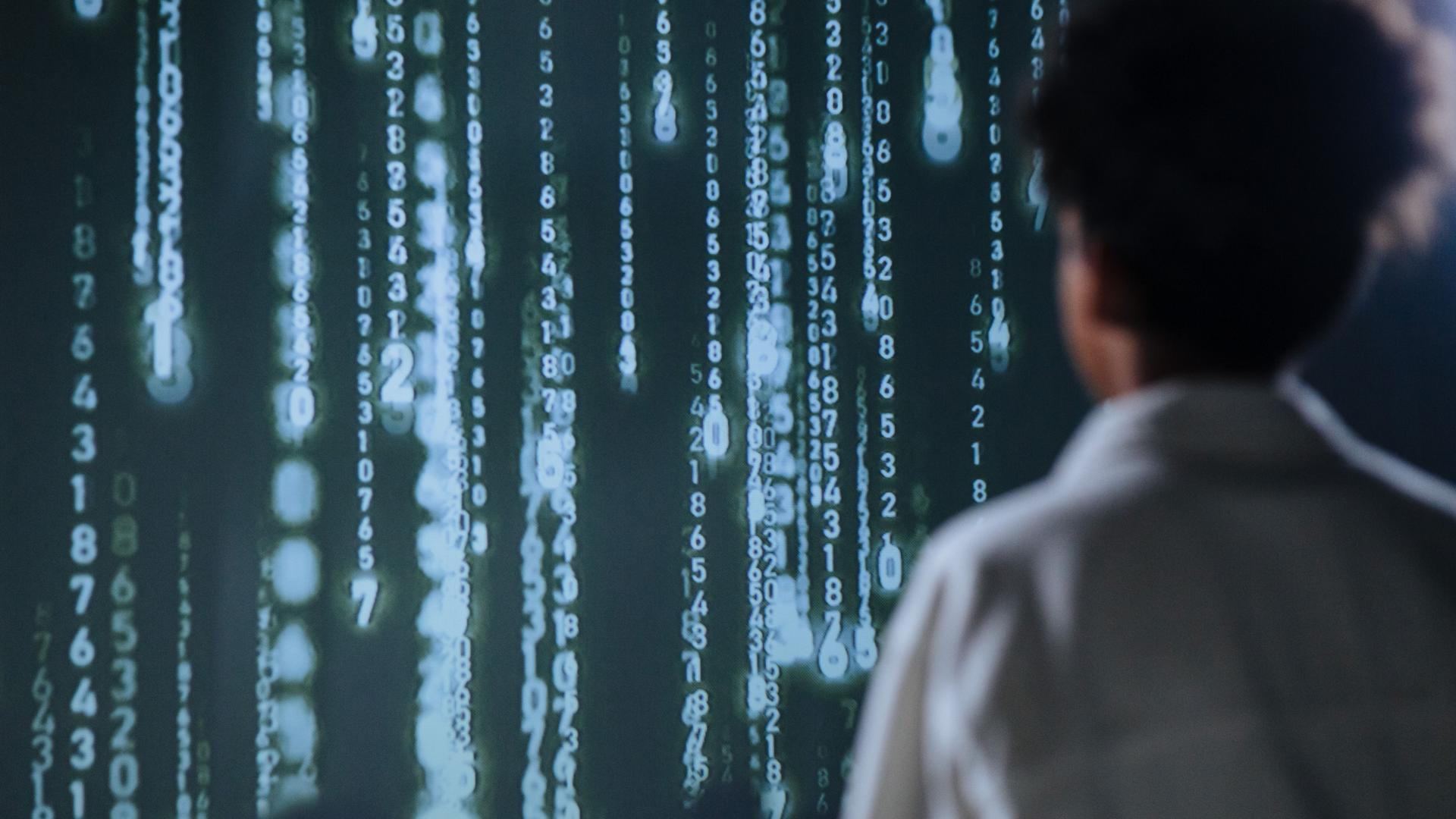 Person in a lab coat views digital data display, highlighting AI's complexities and the importance of ai laws.