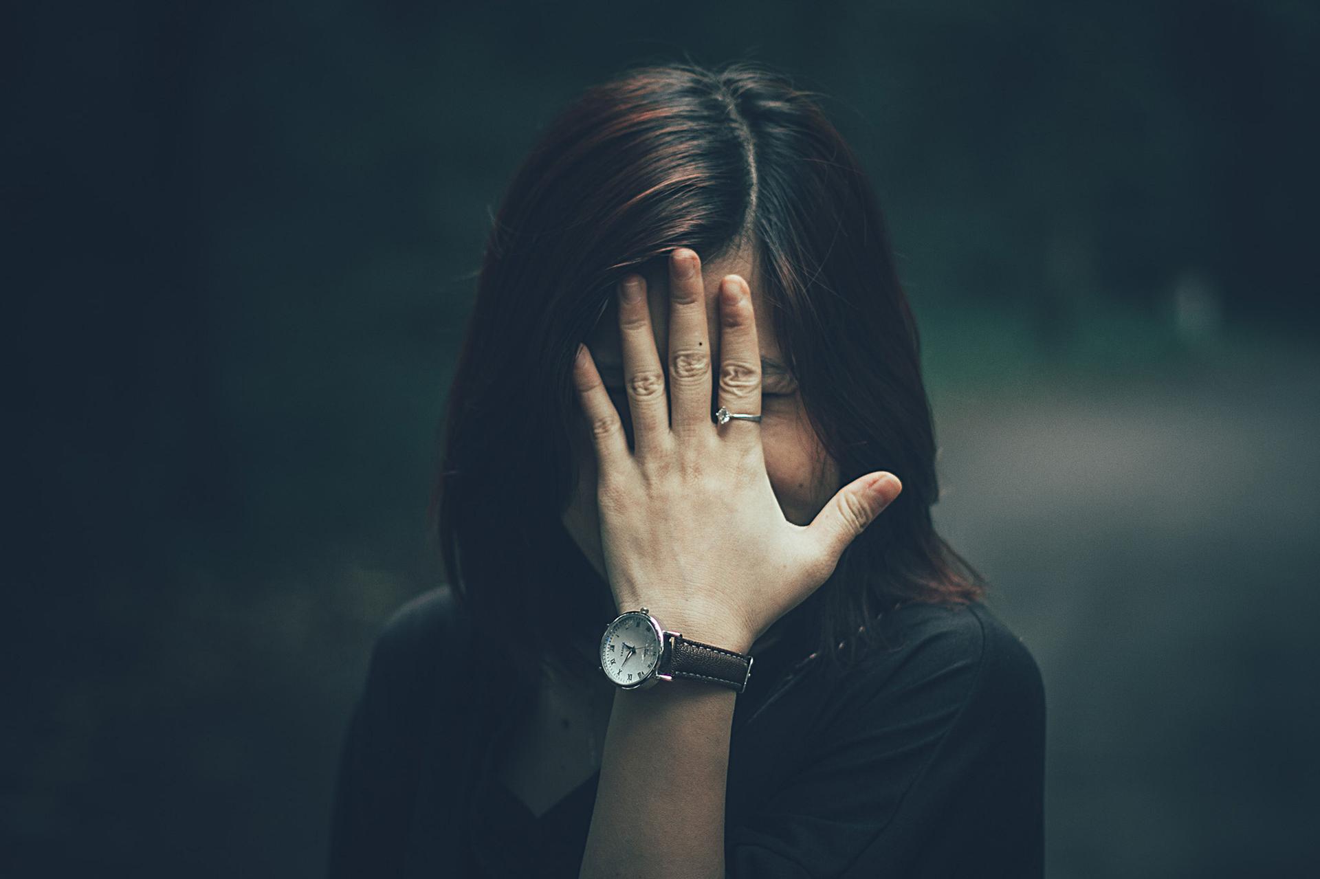 Woman covering her face symbolizes how rogue AI headlines obscure real security failures.