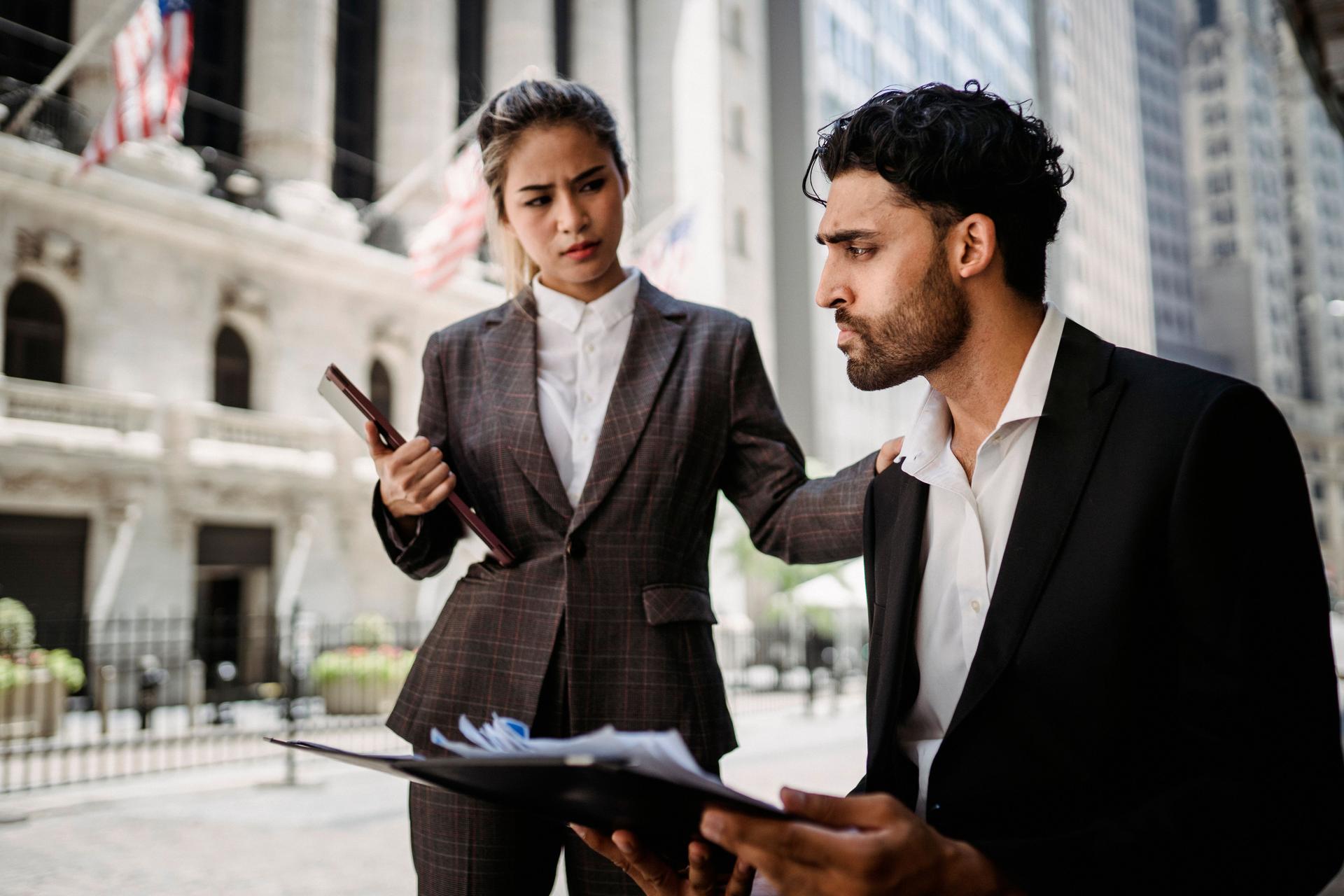 Woman advises concerned man near financial institution, highlighting AI laws' ethical implications.