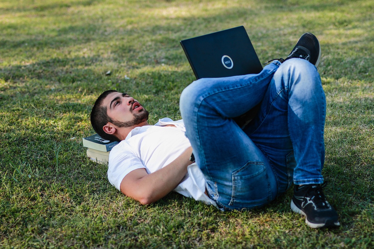 A young man looks up while using his laptop, reflecting the trend of affordable ai agents.